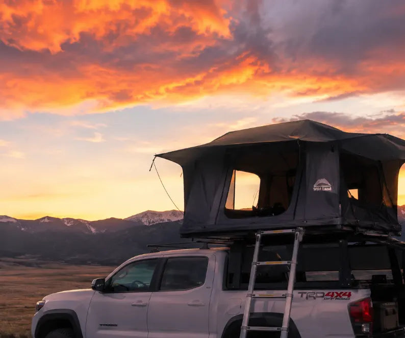A beautiful sunset and the scene of camping on the roof of a pickup truck in the wild